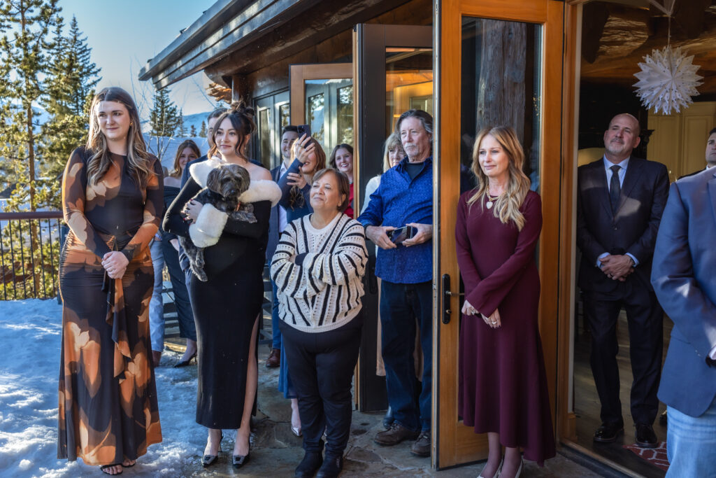 Close family and friends surround bride and groom during intimate elopement ceremony.