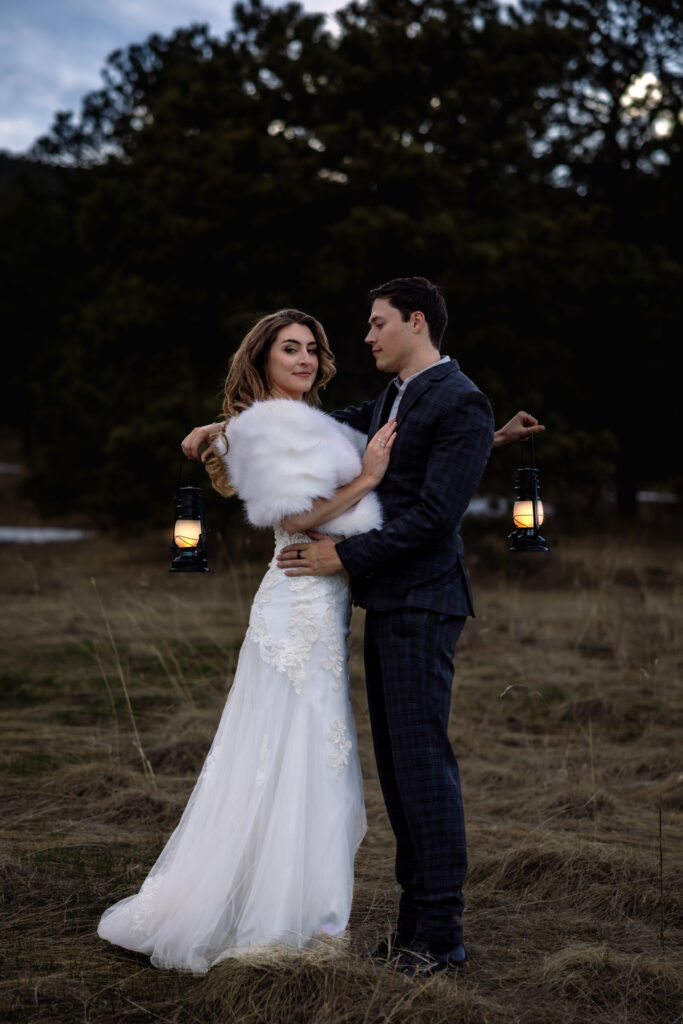 Couple poses at sunset with lanterns at small wedding in Colorado.
