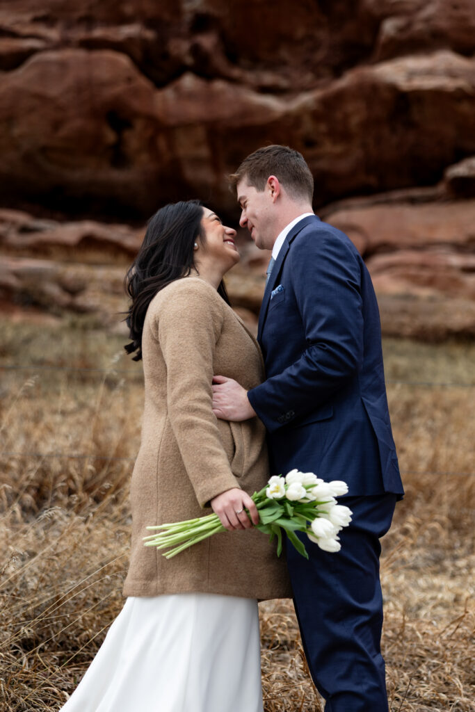 Colorado couple takes photos against red rocks during their intimate elopement.