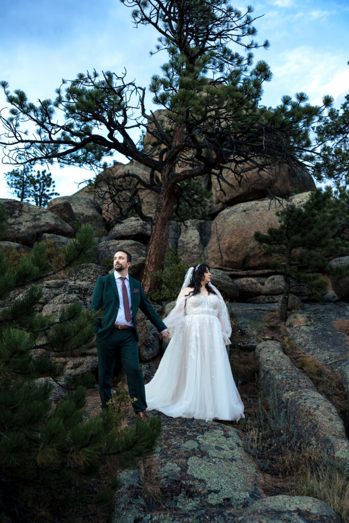 Married couple poses on rocks during their elopement in Estes Park, Colorado.