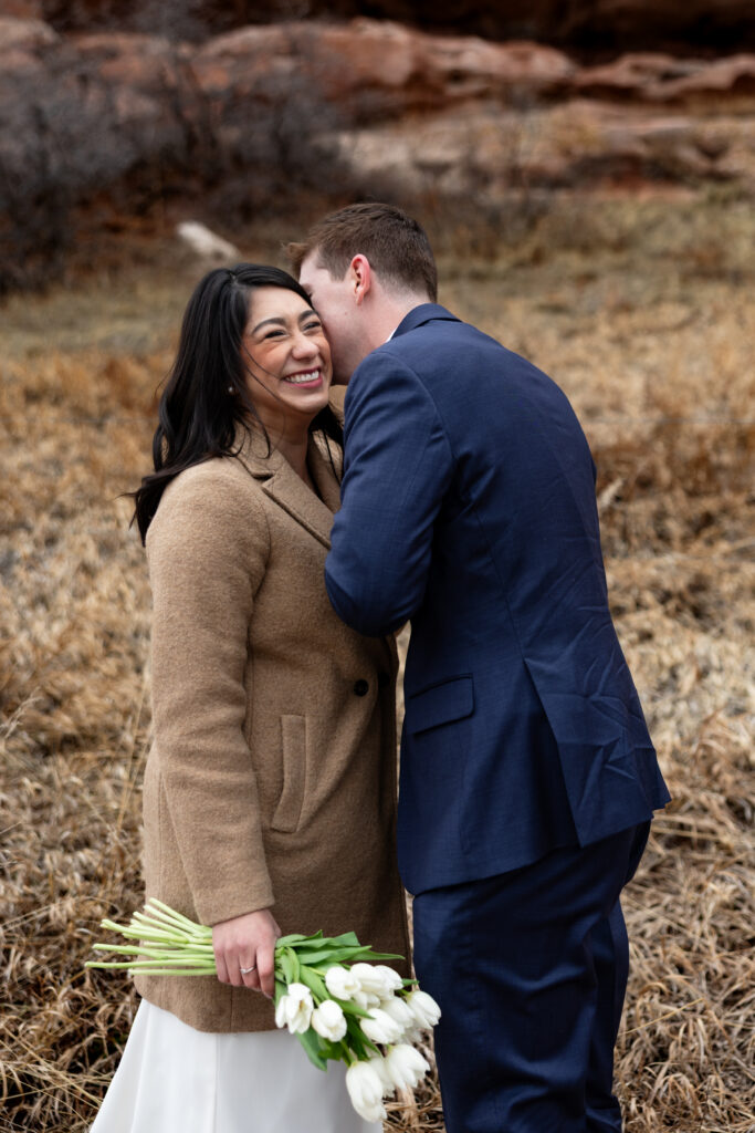Groom makes bride laugh during an intimate Colorado winter elopement.