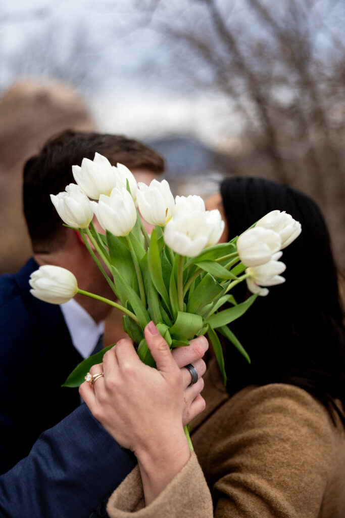 Couple uses bouquet to hide faces during fun Colorado elopement.