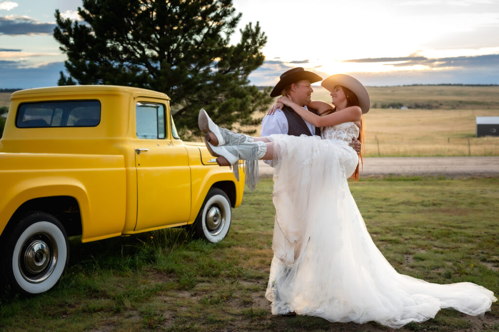 Bride and groom pose near vintage truck during Colorado elopement.