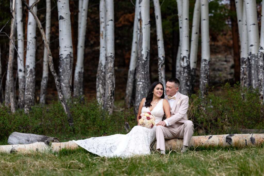 Bride and groom sitting beneath aspen trees during their Buena Vista elopement.