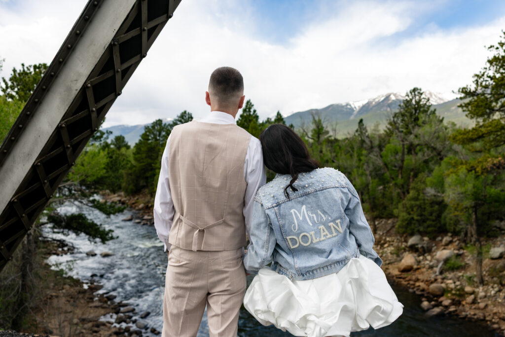 Couple standing above a river during their Colorado ranch elopement.