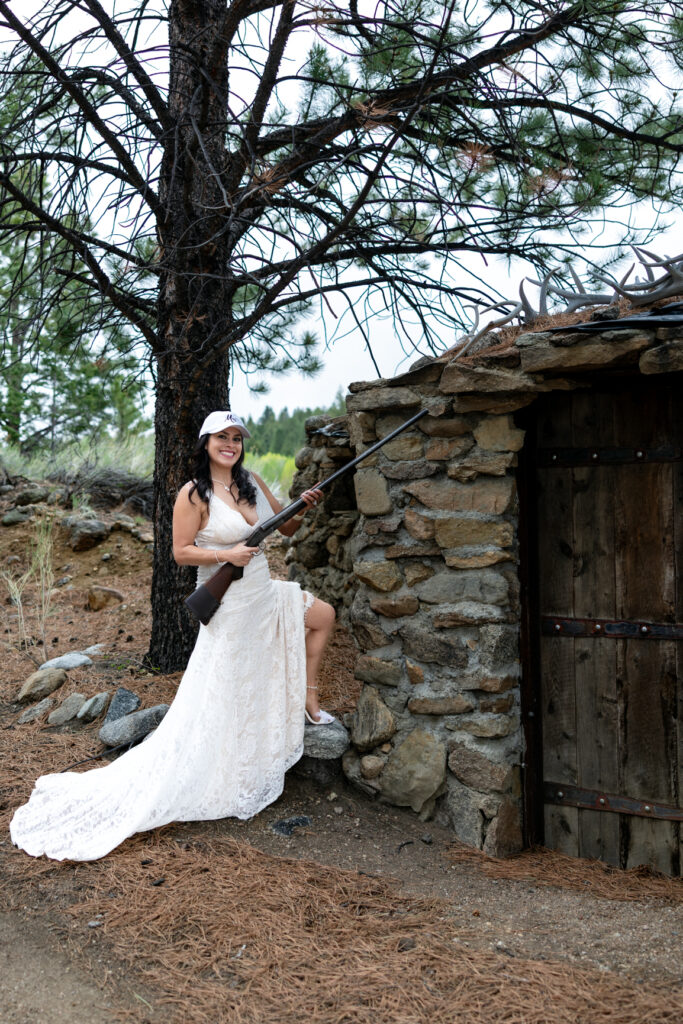 Bride posing with a family heirloom rifle during their Colorado ranch elopement.