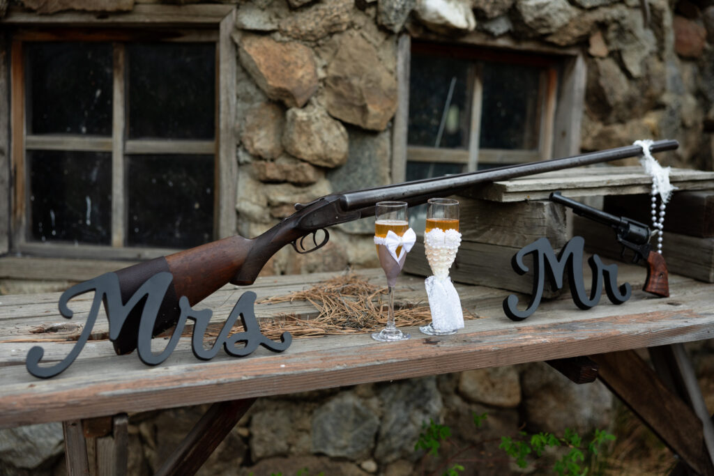 Couple celebrating their Buena Vista elopement with non-alcoholic champagne and hunting rifles.