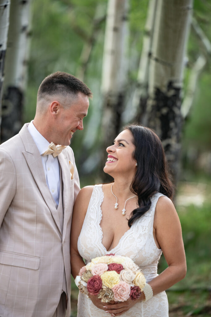 Bride and groom standing beneath aspen trees during their Buena Vista elopement.